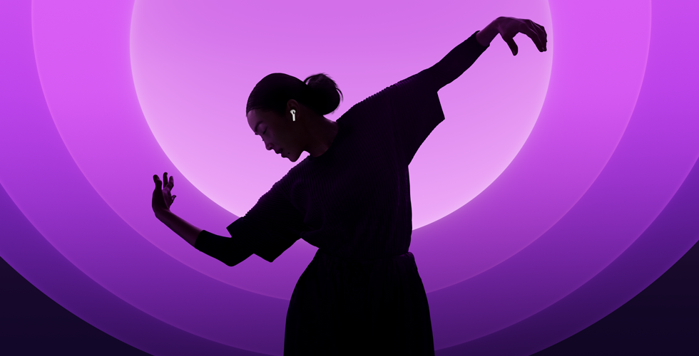 Iemand die danst met AirPods 5 in, tegen een veelkleurige achtergrond